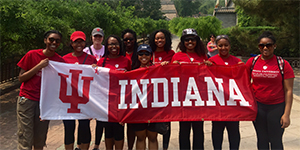 Group of students poses for a photo with IU banner flag.