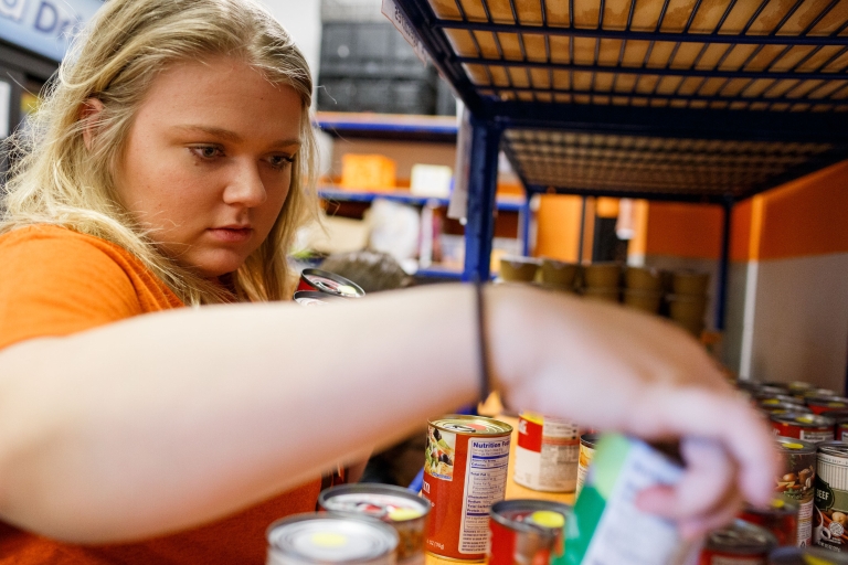 A student helps stock food at Paws Pantry on the IUPUI campus.